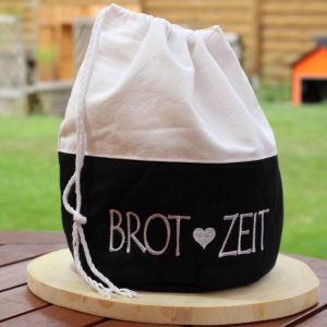 Schwarzer Brotbeutel mit weißem Kordelzug und Aufdruck „Brot Zeit“ – geschlossen