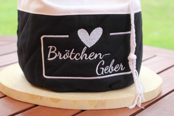 Bestickt mit „Brötchen-Geber“ auf weißem Stoff – Detailfoto