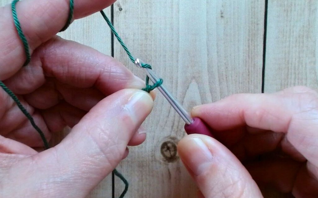 Häkeln lernen: Arbeitsfaden wird mit der Häkelnadel für eine Luftmasche geholt